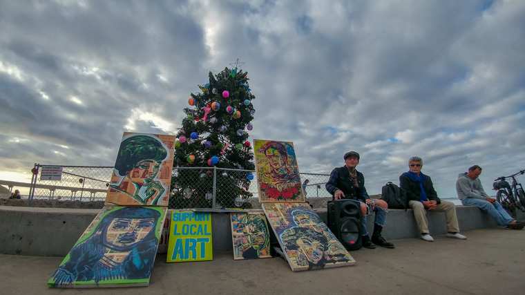 Art merchant in front of the Ocean Beach Christmas Tree (2018)