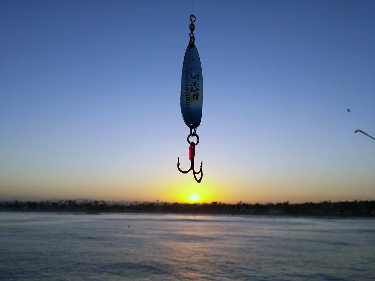 Lure hanging over the sun rise on the Ocean beach Fishing Pier
